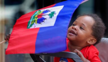 Ozzie Milfort, then 19-months, waved his flag at the start of the Haitian Flag Day parade last month in Mattapan Square.
