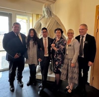 Elder Edwnur Alexander Enrique Ramos Silva (center) stands with his family and service missionary coordinators, Elder Torben Jensen and Sister Lise Jensen, in front of a Christus statue. Elder Ramos Silva is the first ever young service missionary in Iceland, set apart May 12, 2025.