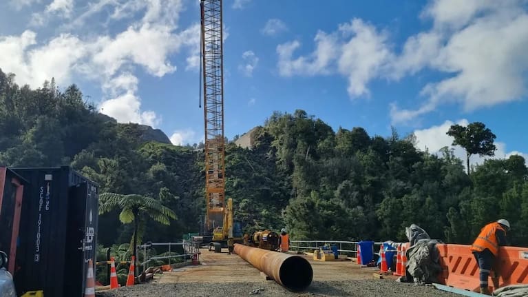 A 28 tonne crane preparing to place a pile from the staging bridge at the construction site of the 125m steel girder bridge.