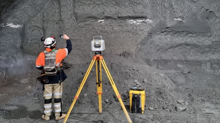 A surveyor working at the tunnel face.