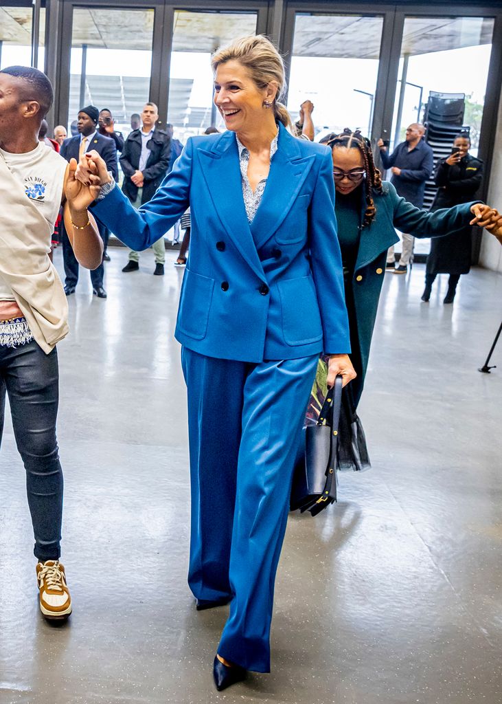 Queen Maxima of The Netherlands visits South Africa is a bold blue suit