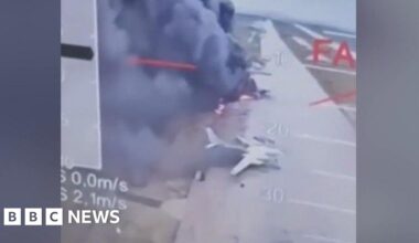 Planes on fire on runway with smoke pluming around them