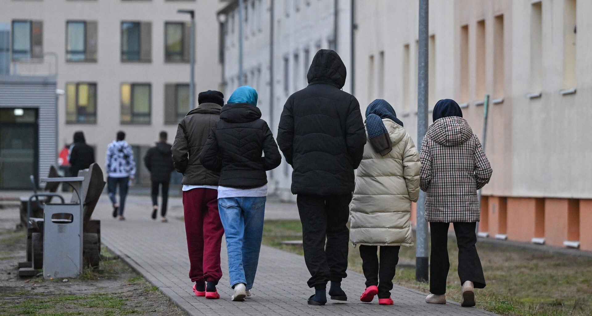 Migranten gehen über das Gelände der Zentralen Erstaufnahmeeinrichtung für Asylbewerber des Landes Brandenburg in Eisenhüttenstadt.