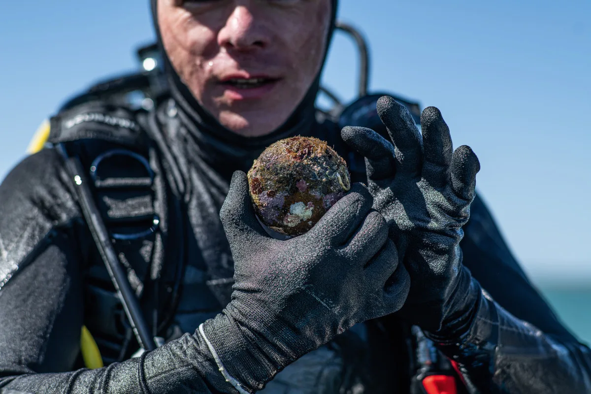 A diver showing us a stone artefact they recovered from the seabed.