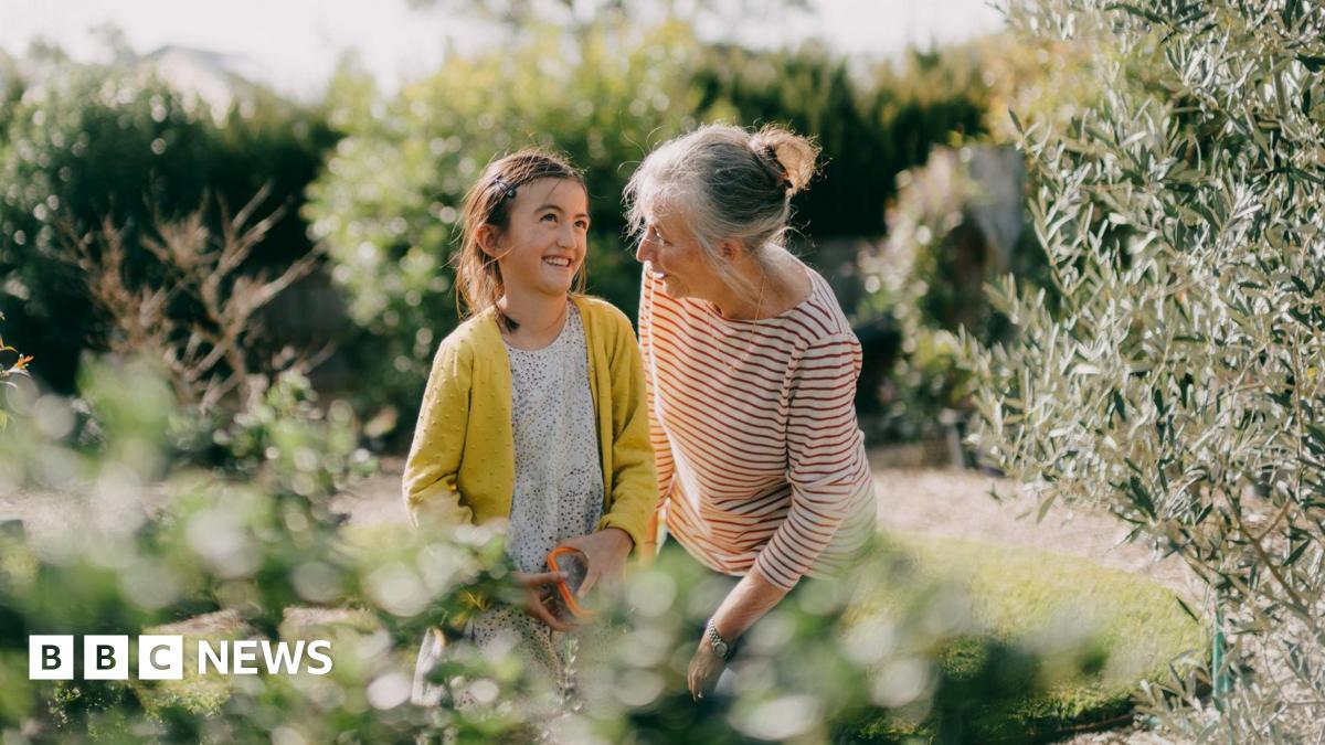 Older woman with a young girl in a garden.
