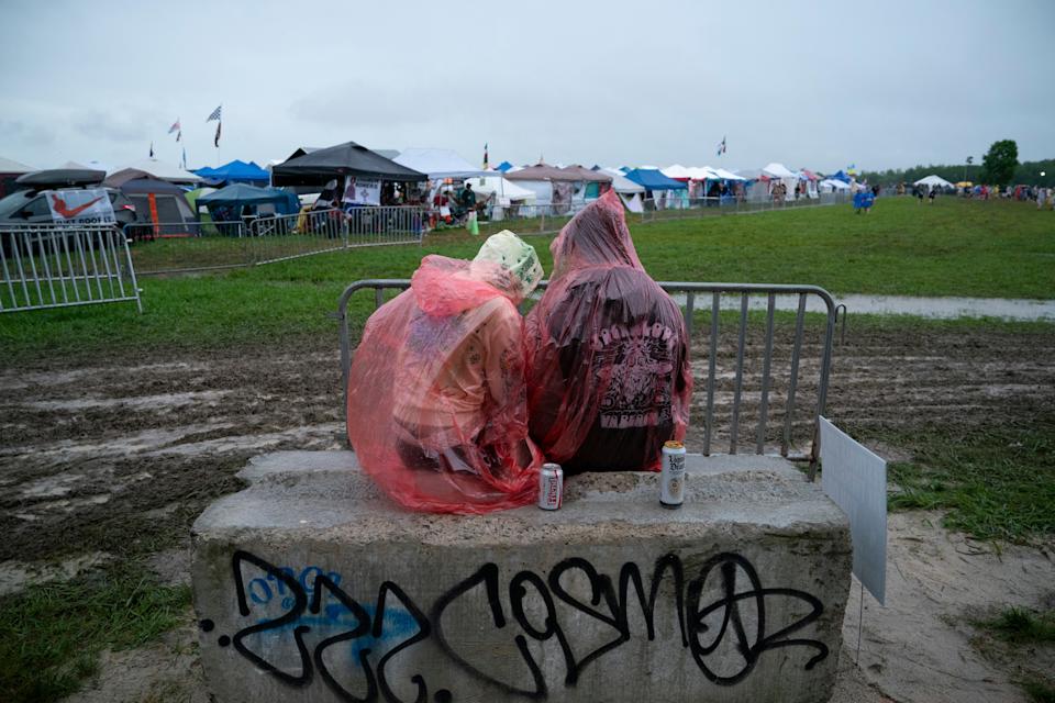 Two Bonnaroovians, Monet Dunham, left, and Clayton Hogins, both of Virginia Beach, Va., wait in the rain for the festival to resume during the second day of Bonnaroo Music & Arts Festival at The Farm in Manchester, Tenn., Friday, June 13, 2025. It was later announced the festival would be canceled for the remaining two days due to the heavy rains.