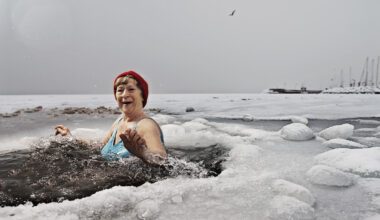 A woman bathes in a hole in the ice on a frozen sea.