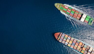 High aerial top down view of two container cargo ships traveling over open ocean