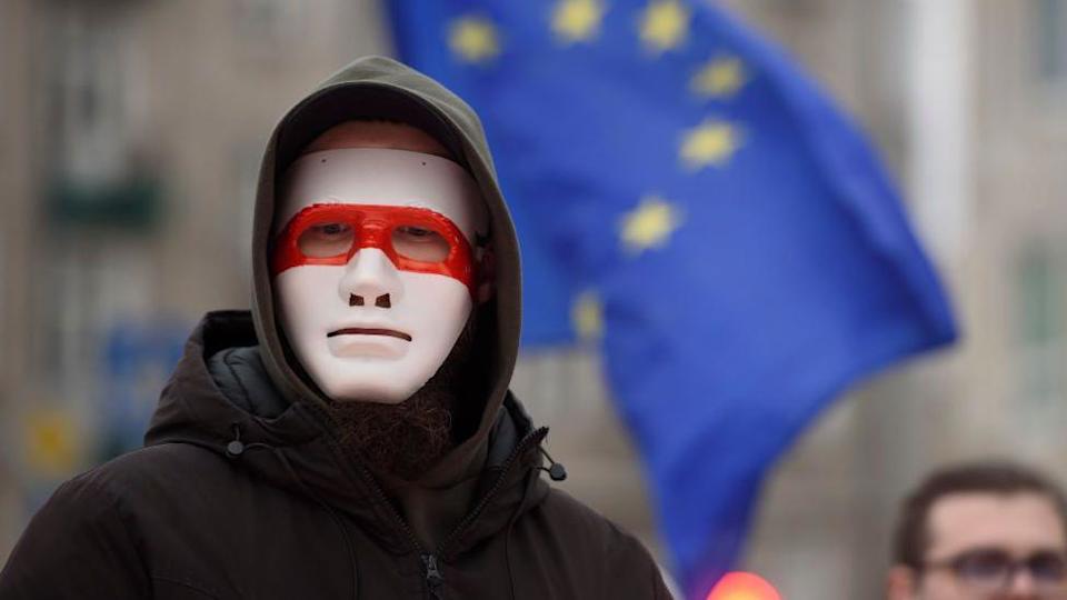A man wears a mask bearing the colours of the historical flag of Belarus as he takes part in the March of Belarusians in Warsaw, Poland on January 26, 2025.