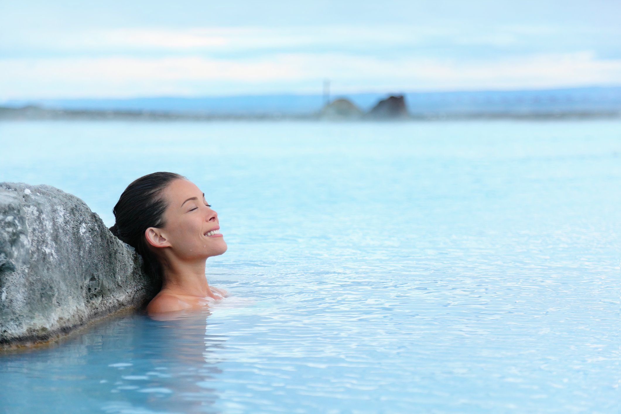 Woman relaxing in a geothermal hot spring pool