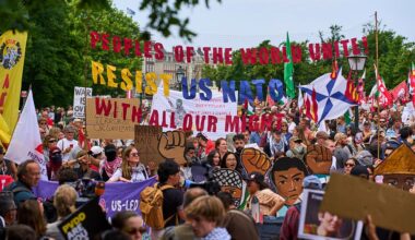 A woman holds a placard during a demonstration ahead of the NATO summit in The Hague, Netherlands, Sunday, June 22, 2025.