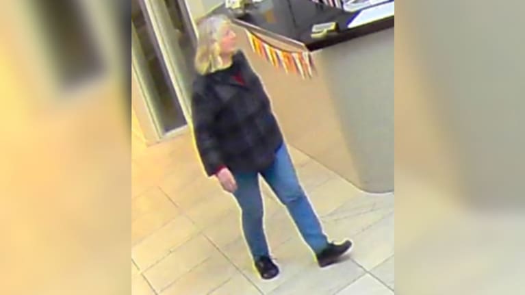 Elisabeth Nicholls was wearing blue pants, a dark coloured long-sleeve top, and black shoes.