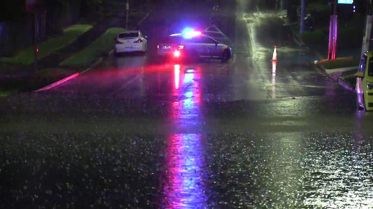 Emergency services close a road in Auckland's Manurewa following heavy weather. 
