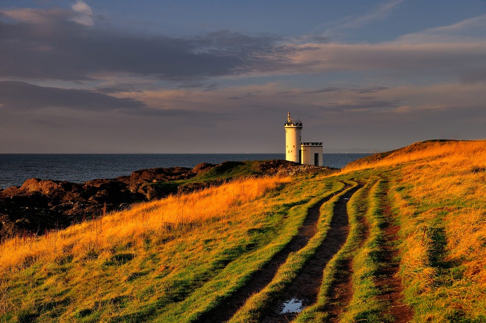 looking out across the firth of forth, elie ness lighthouse catches the first light of day