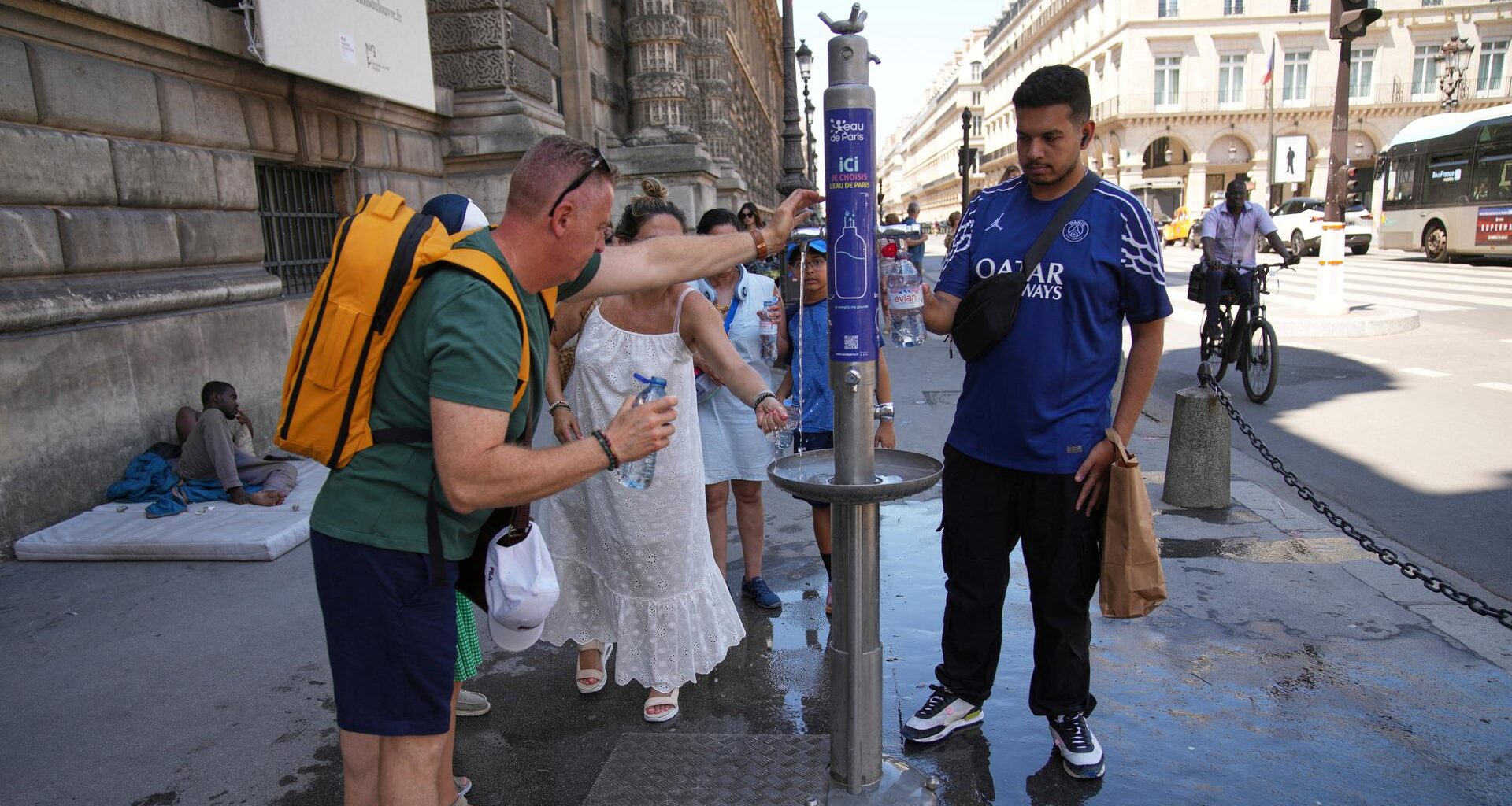 Paris: Während einer Hitzewelle nutzen Menschen einen Straßenbrunnen zur Abkühlung.