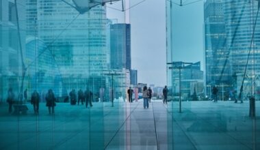 Workers walk through the Grande Arche office block at the end of the day in the La Defense business district, in Paris
