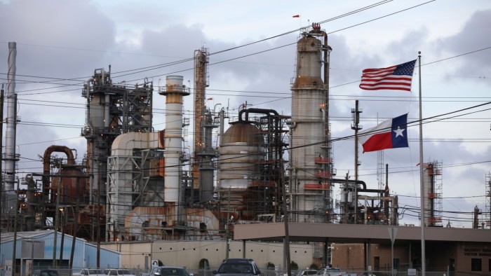 A US and Texas flag stand in front of the Chevron’s Pasadena refinery in Pasadena, Texas