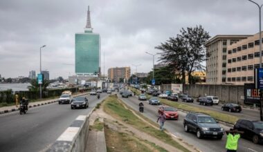Traffic on an African city highway with modern office blocks in the background