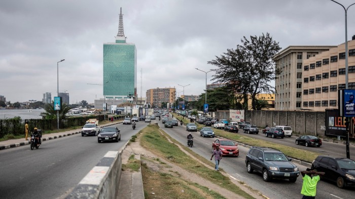 Traffic on an African city highway with modern office blocks in the background