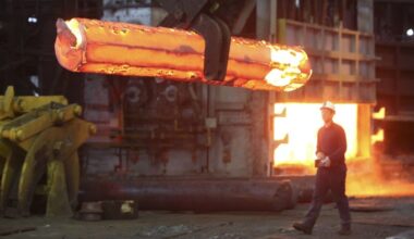 An employee walks behind a steel ingot at Sheffield Forgemasters in Sheffield