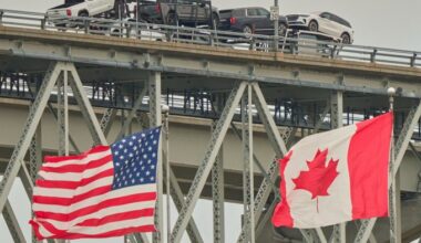 A truck with vehicles crosses the Blue Water Bridge border crossing into the US from Sarnia, Ontario, Canada