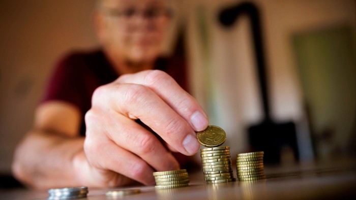 An old man counts money at home in Berlin