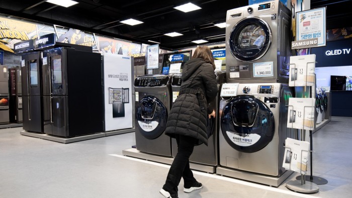 A woman looks at an appliance in a showroom