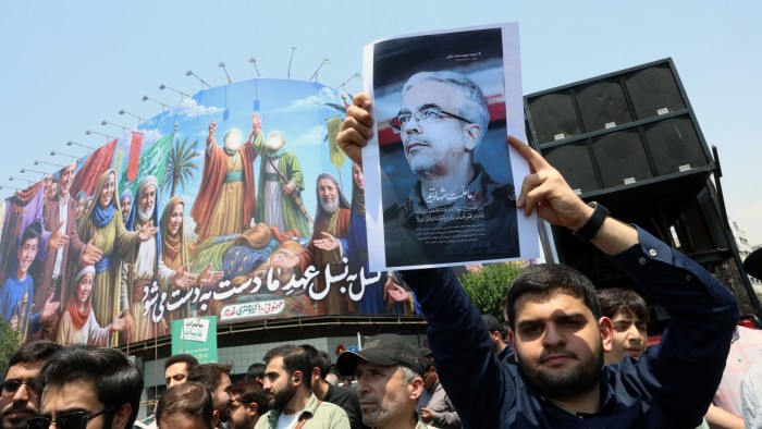 An Iranian holds a poster of Iranian Armed Forces Chief of Staff General Mohammad Bagheri who was killed in an Israeli airstrike