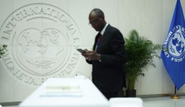 A man reads his phone during the annual Spring Meetings at the IMF headquarters on April 15, 2024 in Washington, DC.