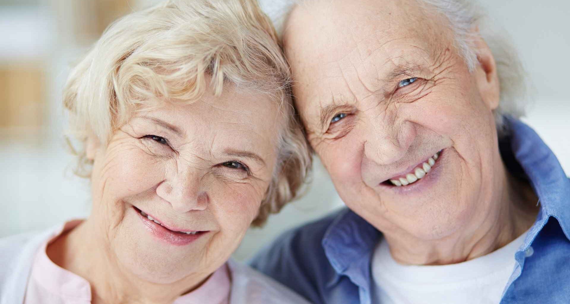 Smiling elderly couple embracing at home, representing retirees living on Social Security income and managing expenses