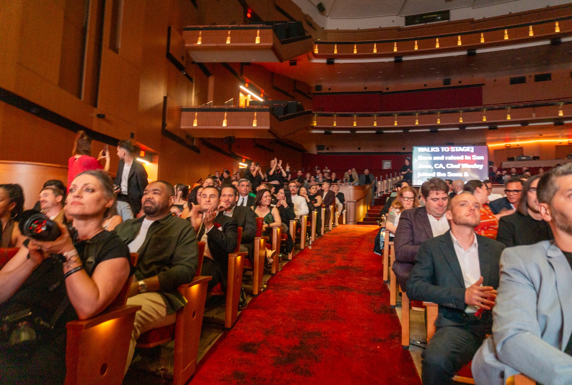 Viewers at the Michelin Guide Ceremony in California in a red carpeted performing arts center.