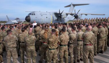 Der britische Premierminister Keir Starmer steht vor einer Maschine der Royal Air Force. Davor haben sich zahlreiche Soldaten versammelt.