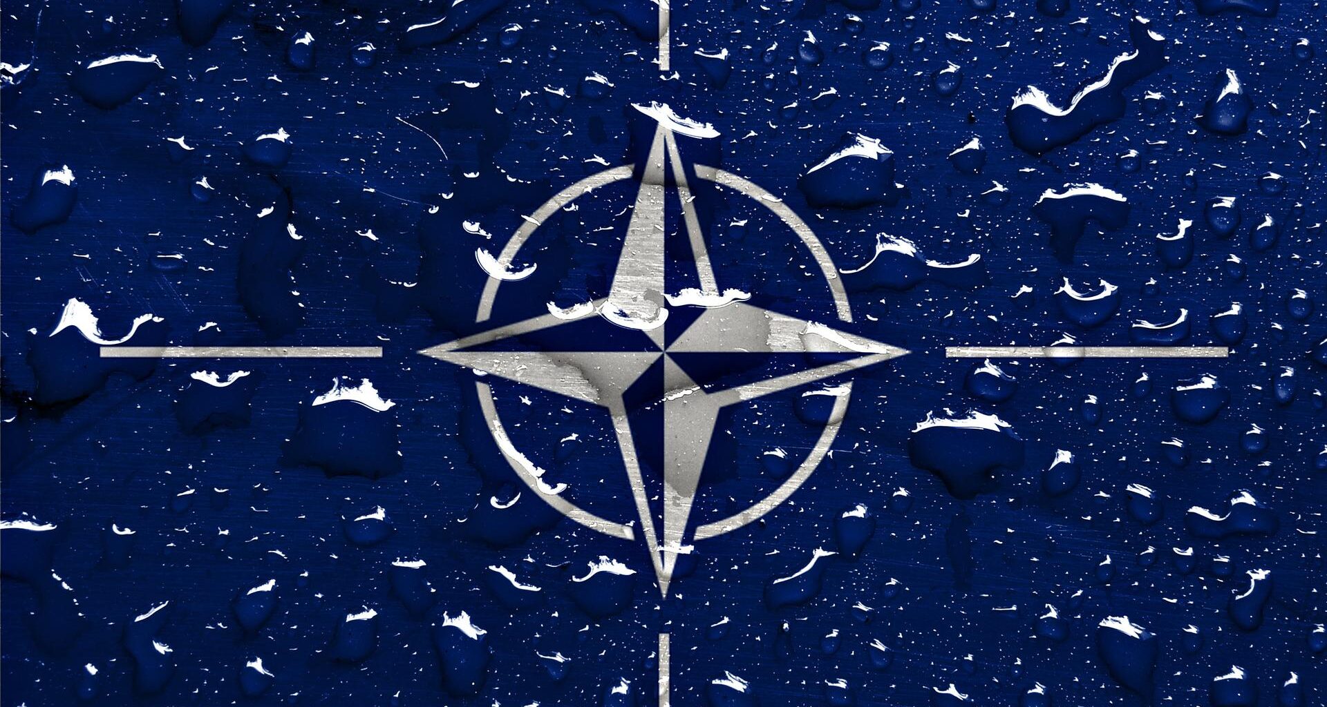 Regentropfen sind auf dem NATO-Logo zu sehen.