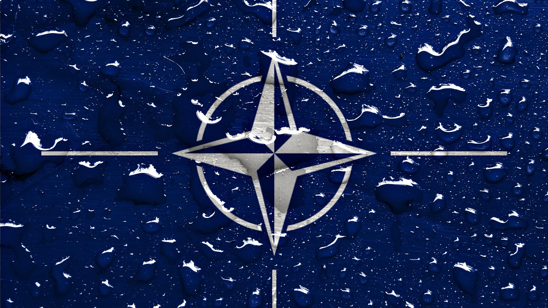 Regentropfen sind auf dem NATO-Logo zu sehen. Regentropfen sind auf dem NATO-Logo zu sehen.