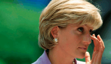 Princess Diana wearing a lavender suit and wiping her eye