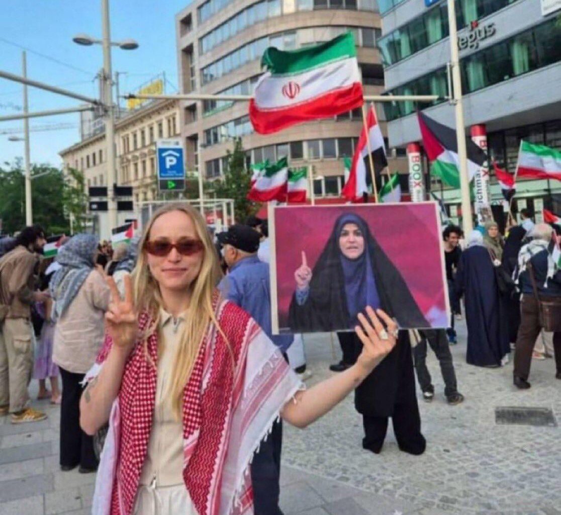 Brave German activist risks nothing to support everything she doesn’t understand. Performative solidarity strikes again