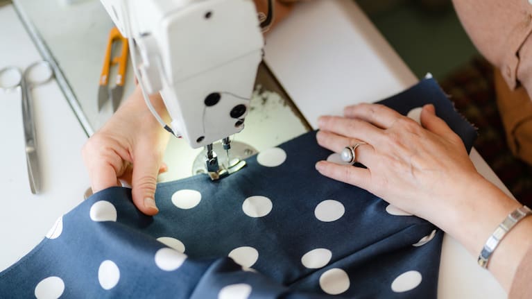 Sewing machine needle and seamstress's hands.