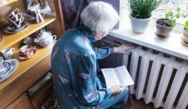 An elderly woman checking the warmth of her radiator. Pic: iStock