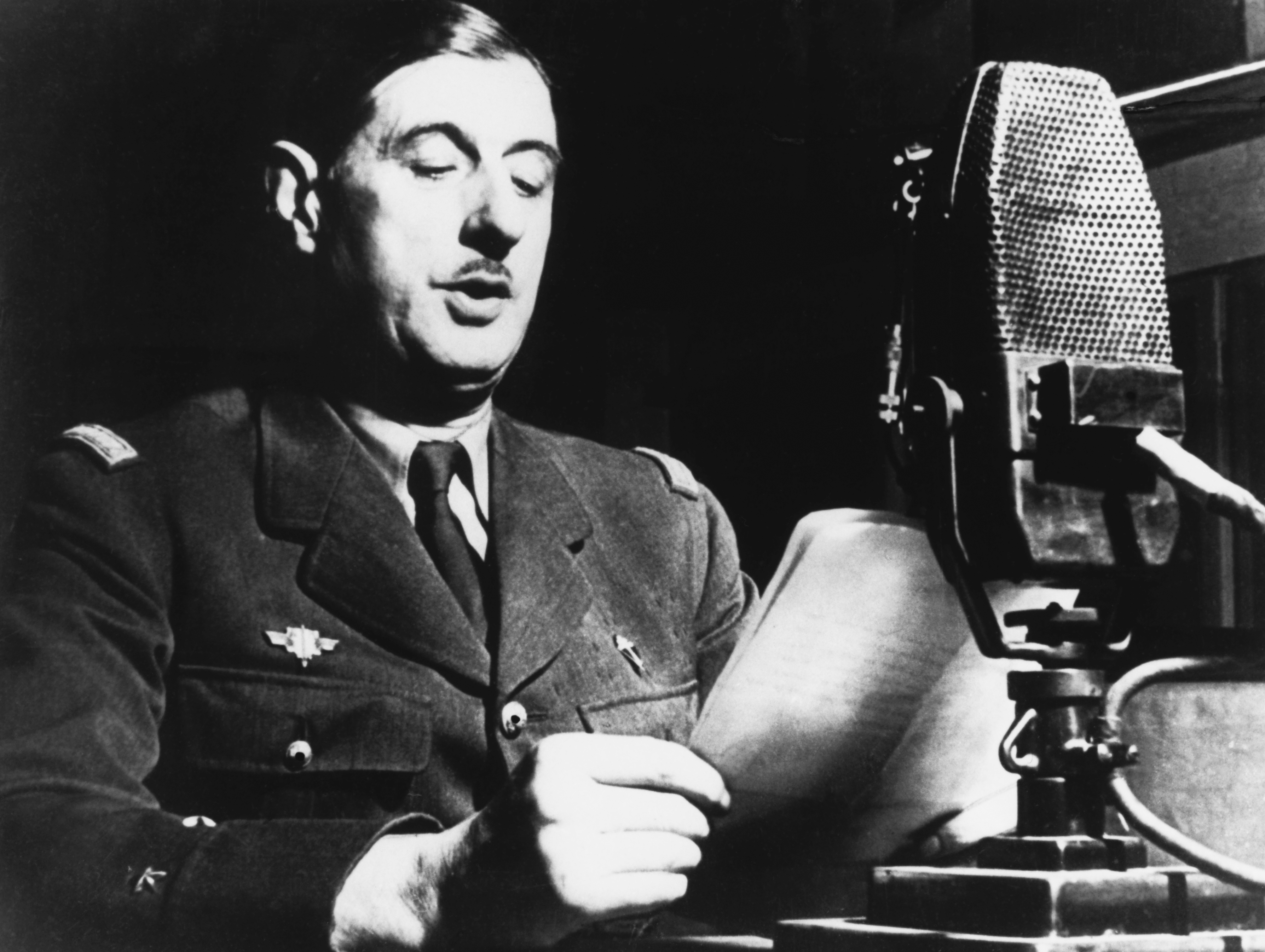 Charles de Gaulle speaking into a microphone.