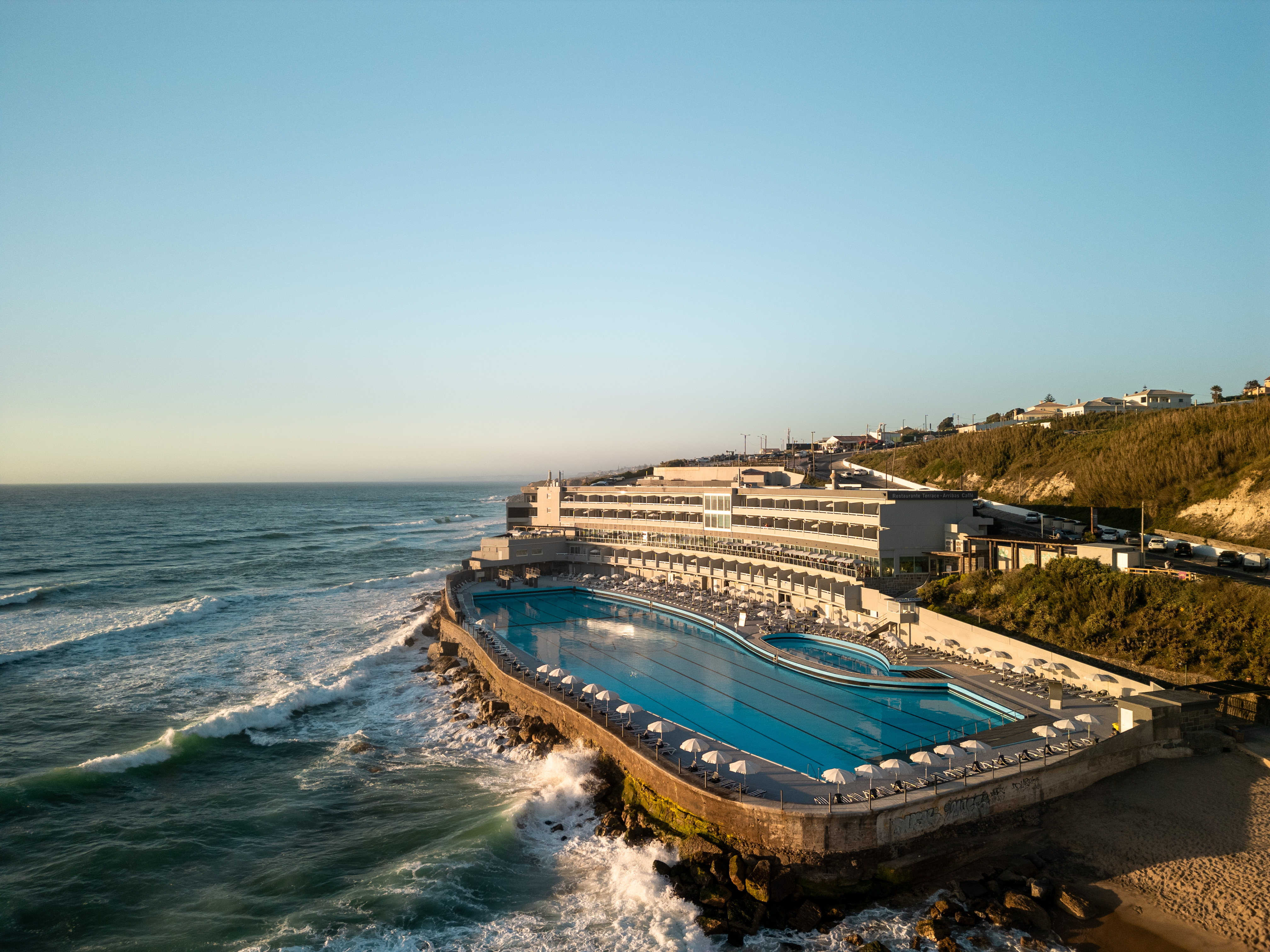 Aerial view of Arribas Sintra Hotel's oceanfront pool and hotel.