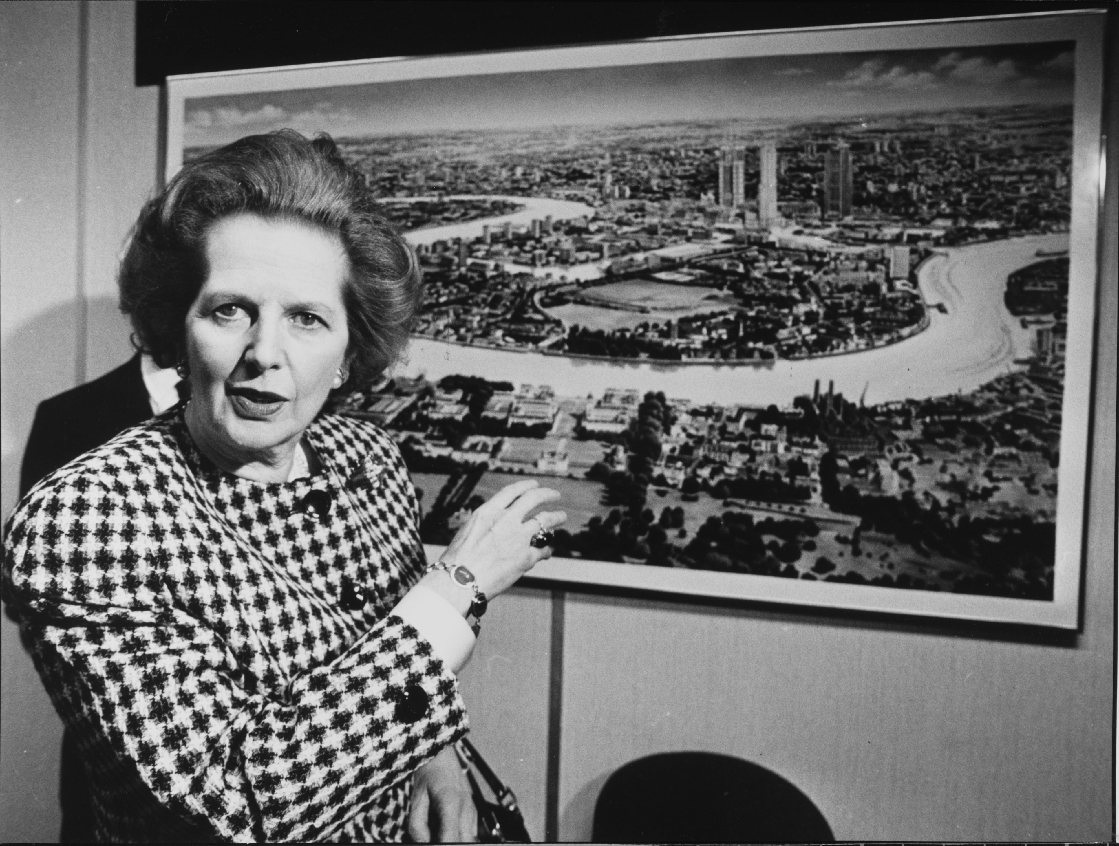 Margaret Thatcher pointing at a map of London's Docklands during an official visit.
