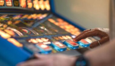 A person presses buttons on a colourful slot machine