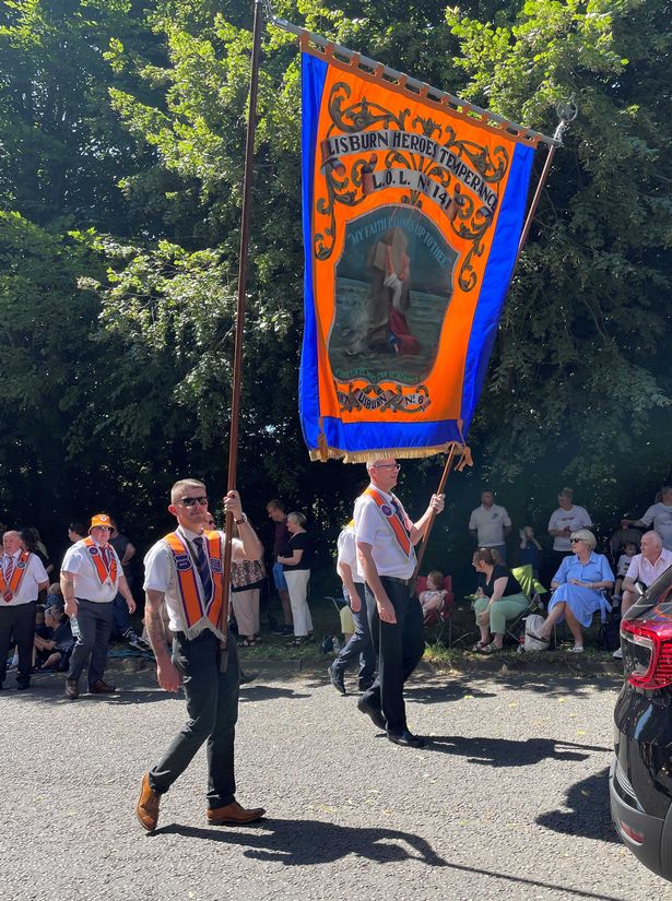 Twelfth of July celebrations in Lisburn showing orangemen with large banner on poles 