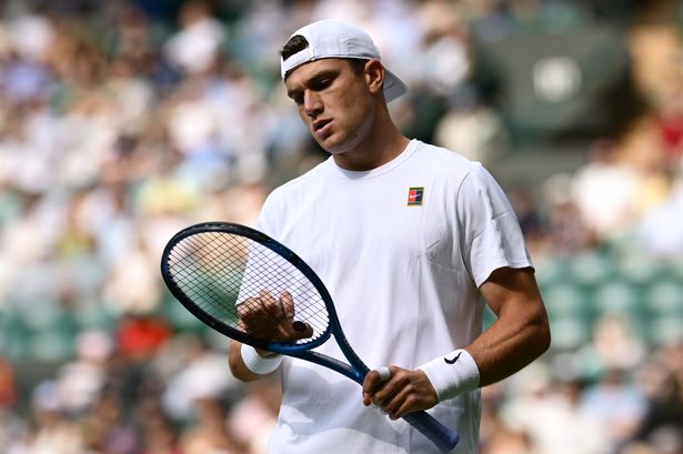 Jack Draper of Great Britain inspects his racket against Marin Cilic