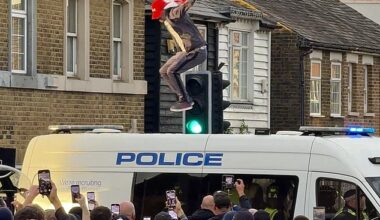 A protestors jumps up and down on the roof of a police van at a protest on July 17 outside The Bell Hotel