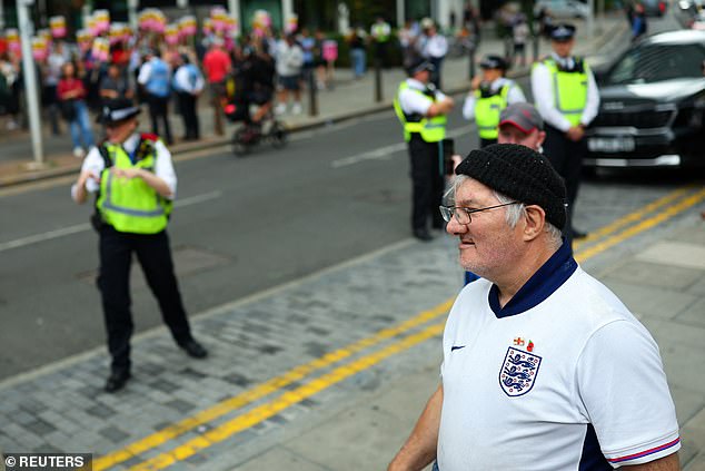 An anti-migrant protester looks on at counter-protesters outside The Britannia International Hotel in Canary Wharf today