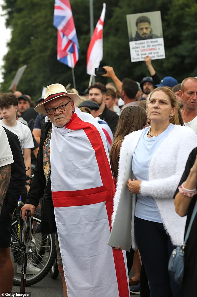 Protesters against asylum seekers being housed in the Brook Hotel protest outside with flags and signs during the demonstration in Norwich