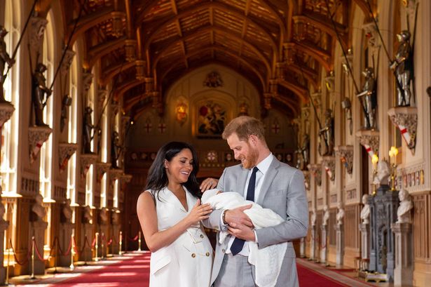 Prince Harry, Duke of Sussex (R), and his wife Meghan, Duchess of Sussex, pose for a photo with their newborn baby son, Archie Harrison Mountbatten-Windsor