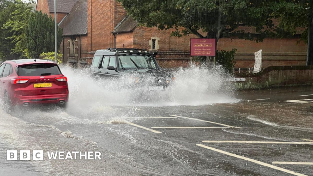 A photo of two cars driving through floodwaters in Norfolk