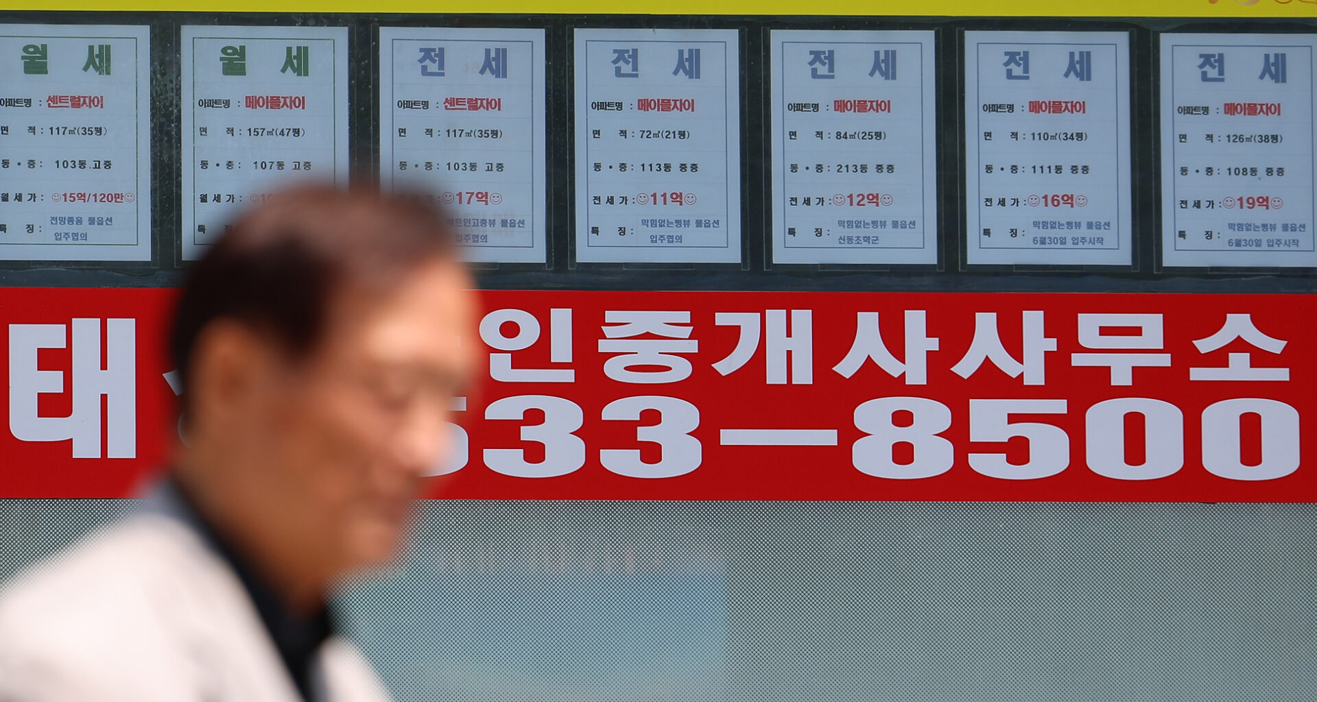 A passerby walks past a real estate agency displaying rental listings in Seoul on June 23 as the city undergoes a sharp rise in housing prices. The uptick in prices has pushed the city’s average jeonse-to-price ratio to its lowest level in over eight years. According to real estate platform R114, the average jeonse ratio-the proportion of rental deposit to property sales price-for 1.57 million apartment units across Seoul's 25 districts fell to 45.2 percent in May, the lowest since January 2017. [YONHAP]